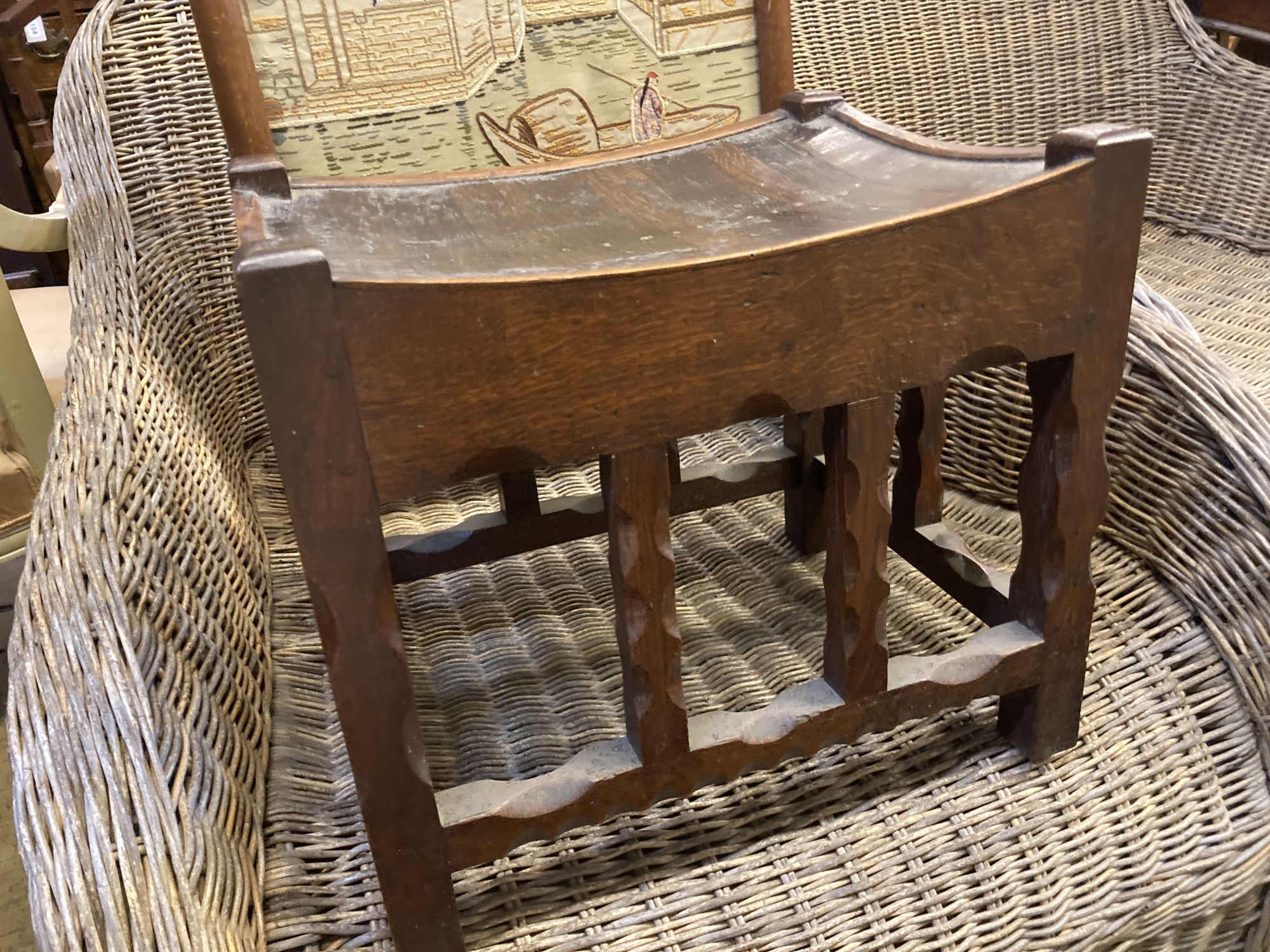 An Arts & Crafts rectangular chip carved oak stool, width 43cm, depth 34cm, height 38cm, together with an embroidered firescreen